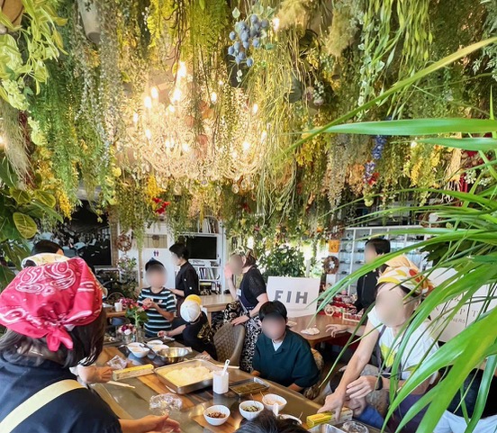 三原庭園内のカフェGivernyでの月例イベントにて ボランティアスタッフと子どもたち、保護者（シスター）が楽しく交流する様子